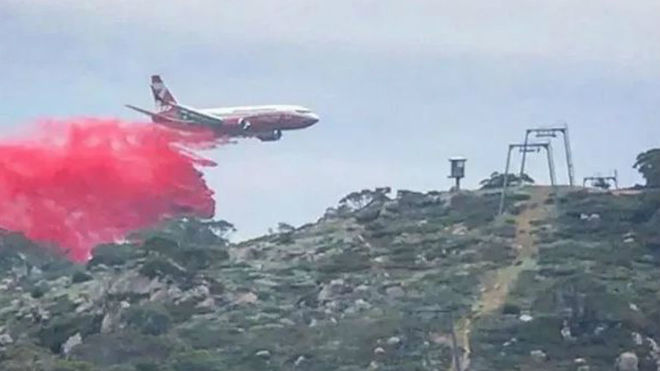 Un avión descarga líquido retardador del fuego sobre Perisher Valley