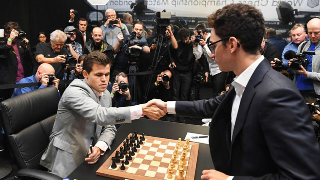 Magnus Carlsen, campeón mundial de ajedrez, saluda al aspirante al título, el estadounidense Fabiano Caruana, antes de comenzar la duodécima partida del Mundial de Ajedrez en 2018.