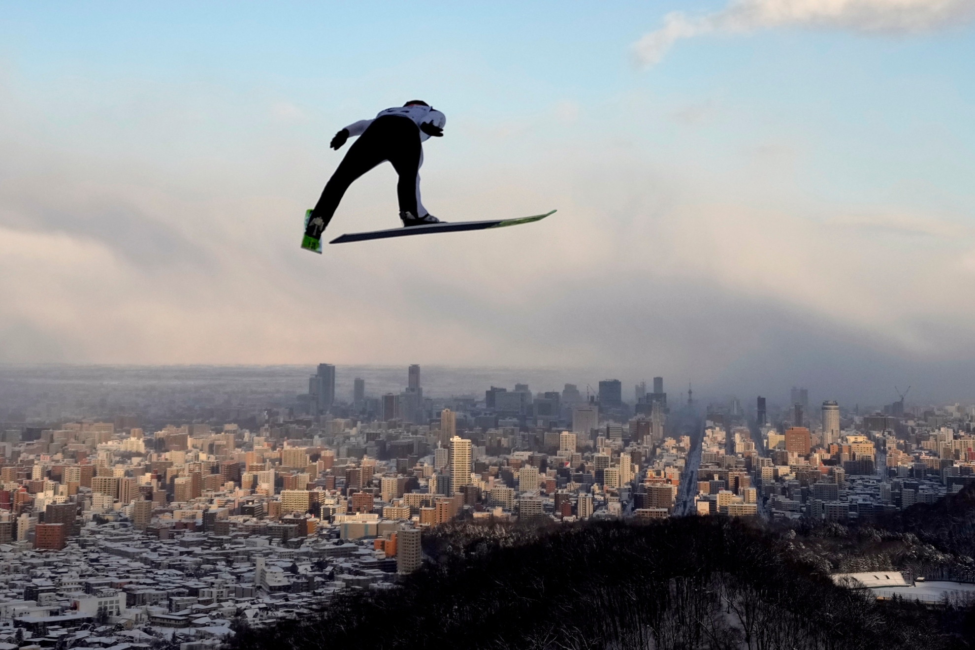 El austriaco Kraft, en uno de sus saltos, con la ciudad de Sapporo al fondo /Efe