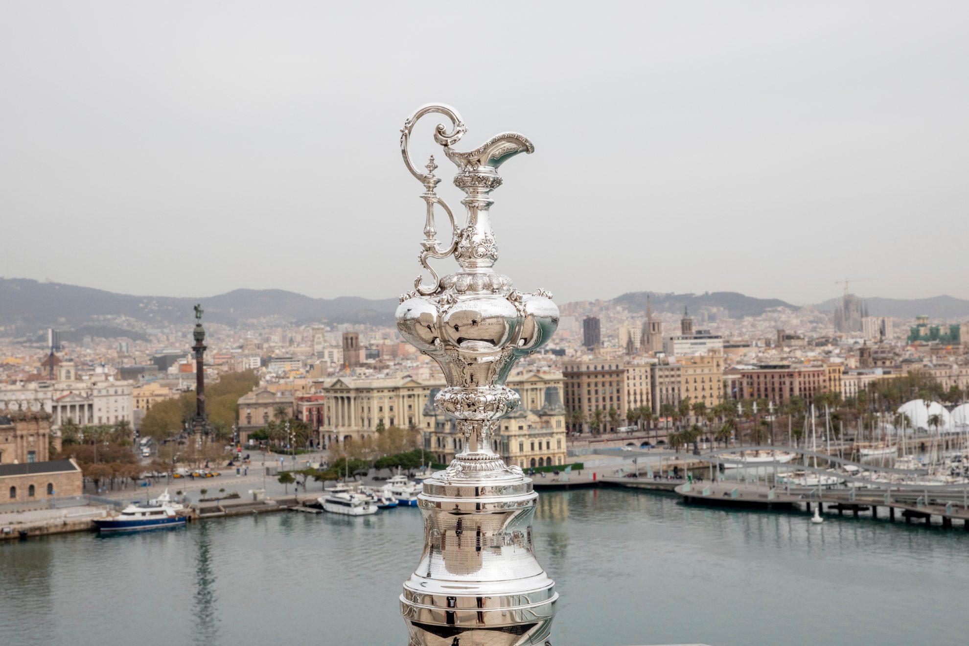 El trofeo de la Copa del América con la ciudad de Barcelona al fondo