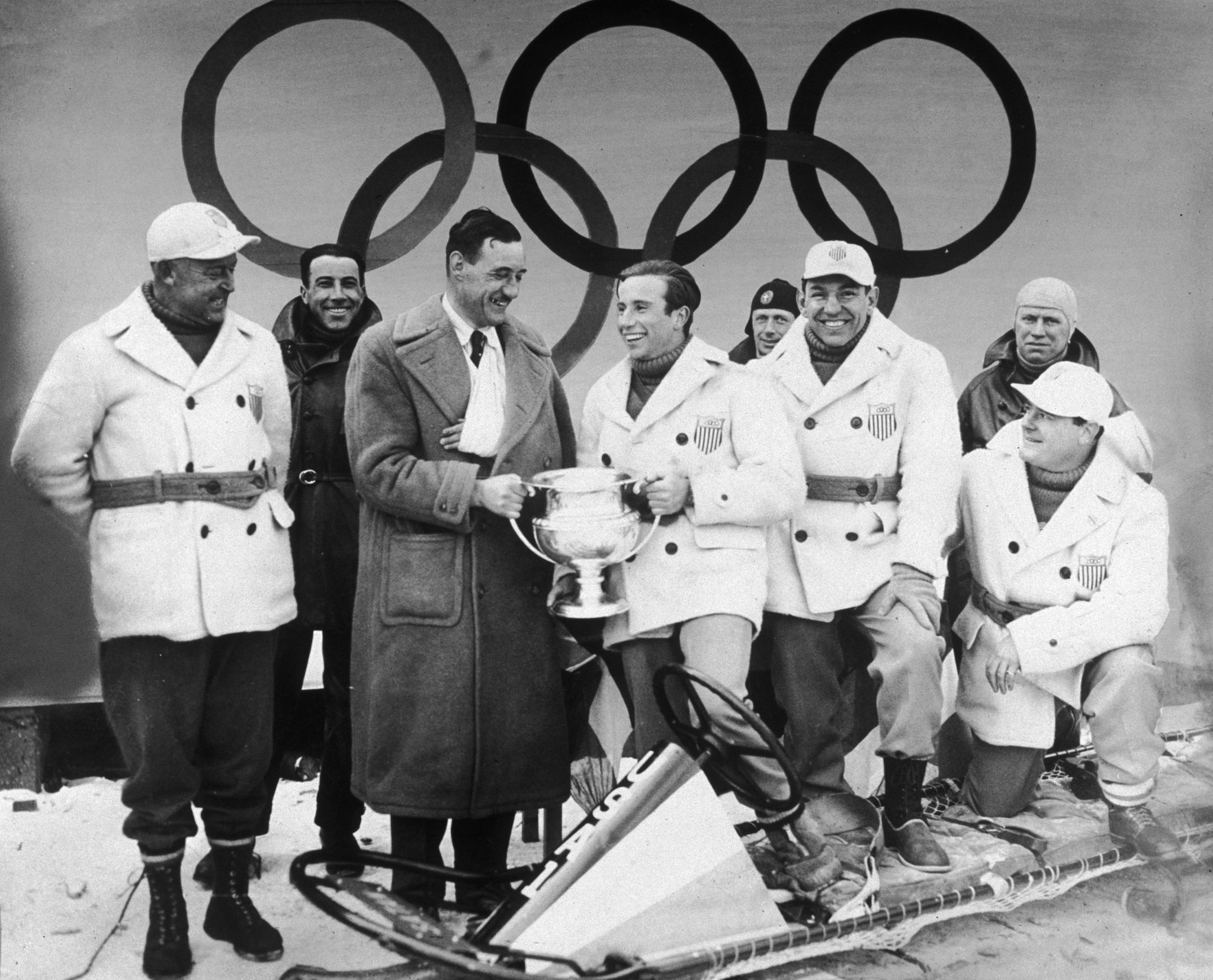 Eddie Eagan, tercero por la derecha, sonríe, mientras su compañero William L Fiske recibe el trofeo como ganador del oro olímpico de bobsleigh en Lake Placid 1932.