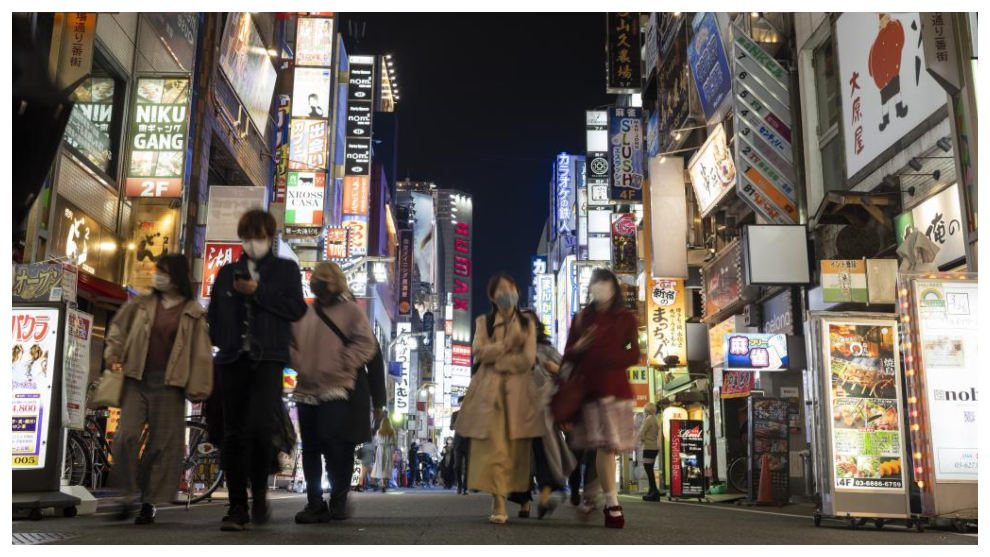 La gente camina por una calle llena de zonas de entretenimiento, restaurantes y bares en el barrio Shinjuku de Tokio.