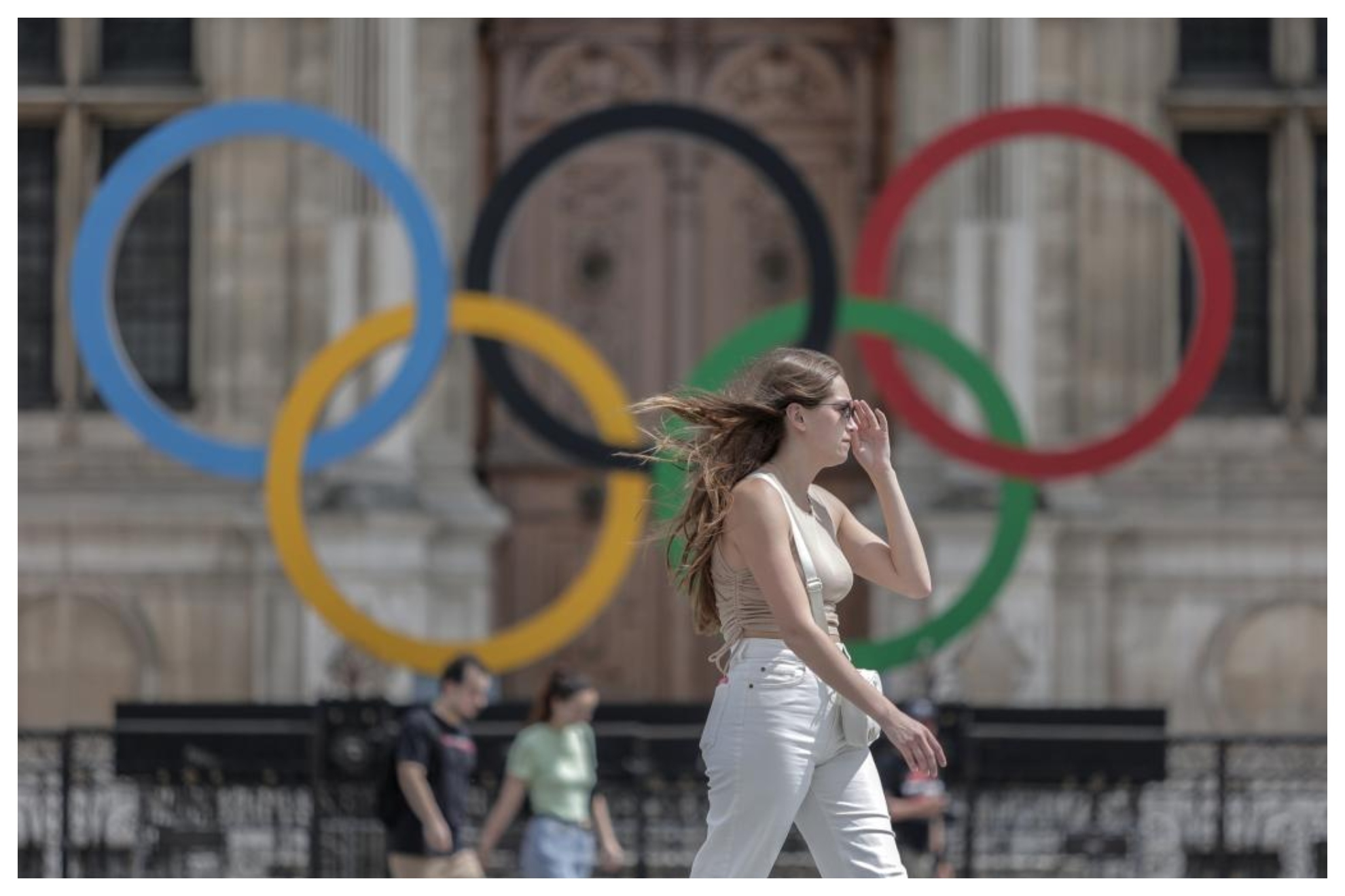 Una ciudadana pasa por delante de los aros olímpicos de París.
