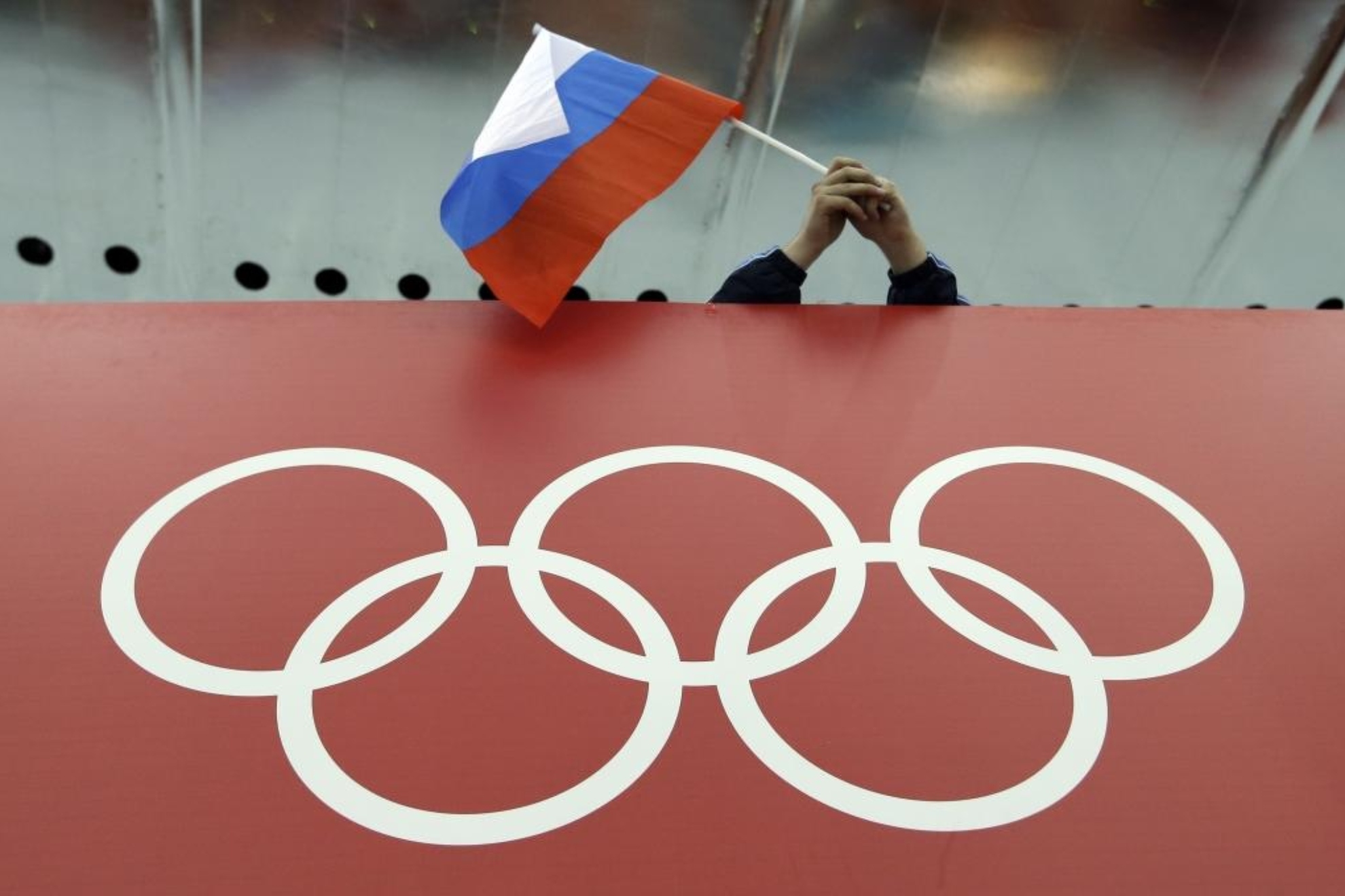 Una bandera rusa junto a los aros olímpicos.