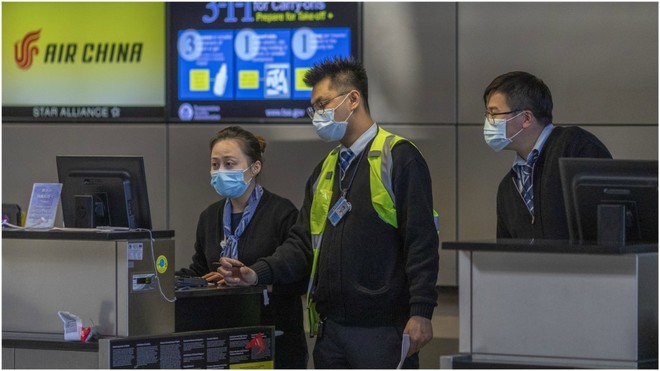 Varios empleados de Air China, en el aeropuerto, con mascarillas