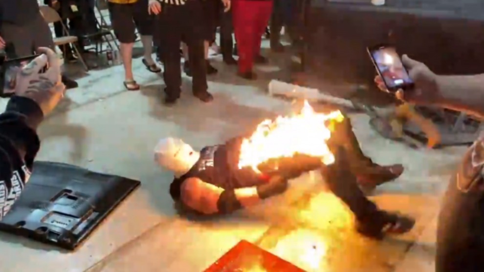 El momento en el que el el luchador intenta zafarse de las llamas.