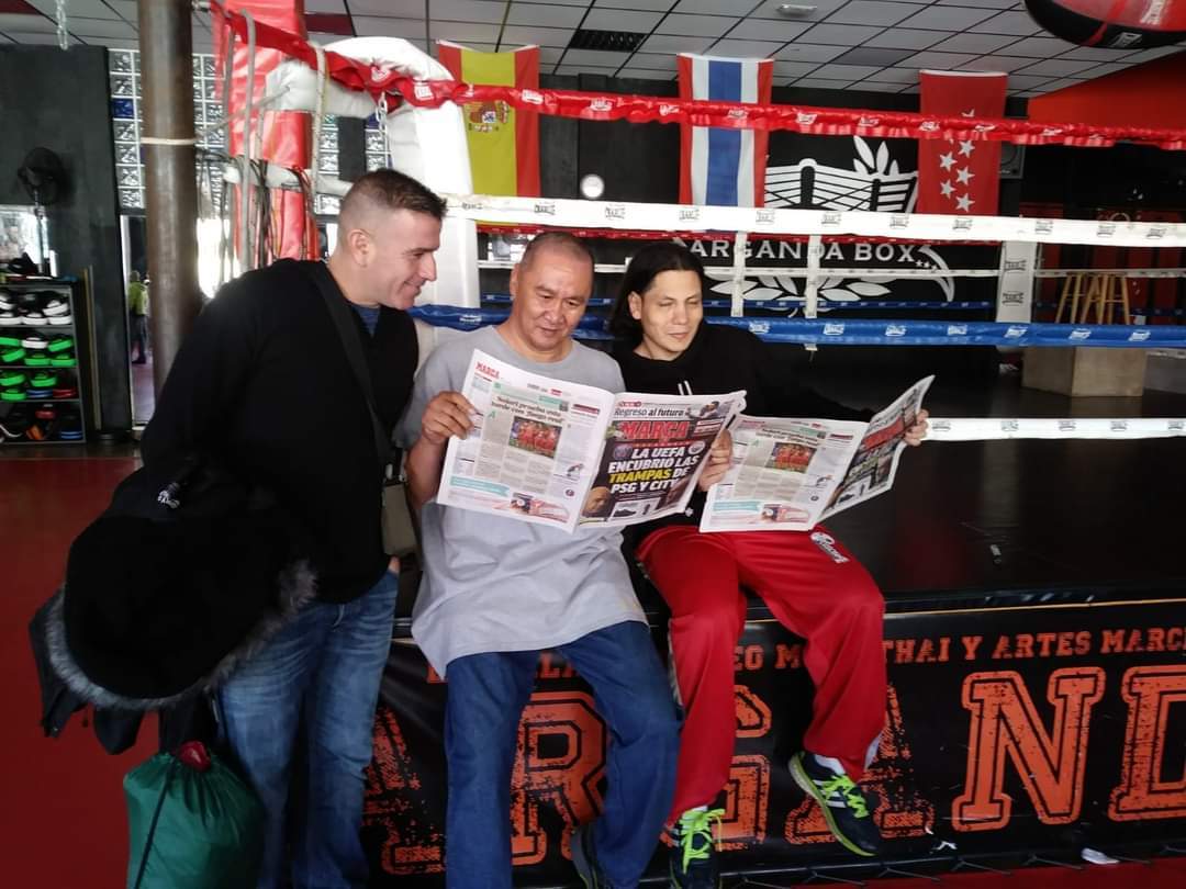 El luchador Nº 1 de la historia del Muaythai Dieselnoi Chor Tanasukarn, con Mario Vega y Carlos Sánchez leyendo MARCA en su visita a España