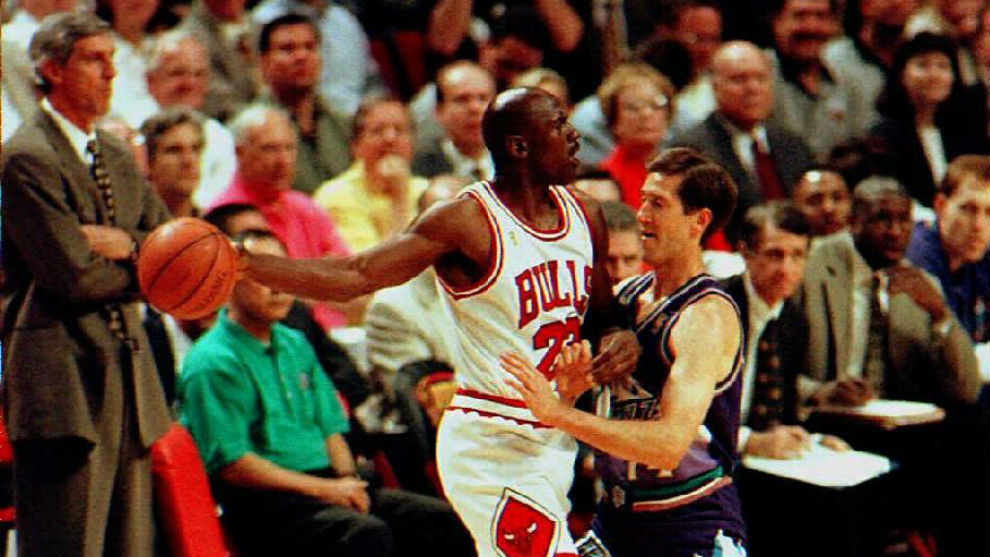 Michael Jordan protects the ball against Jeff Hornacek in a Bulls-Jazz game.