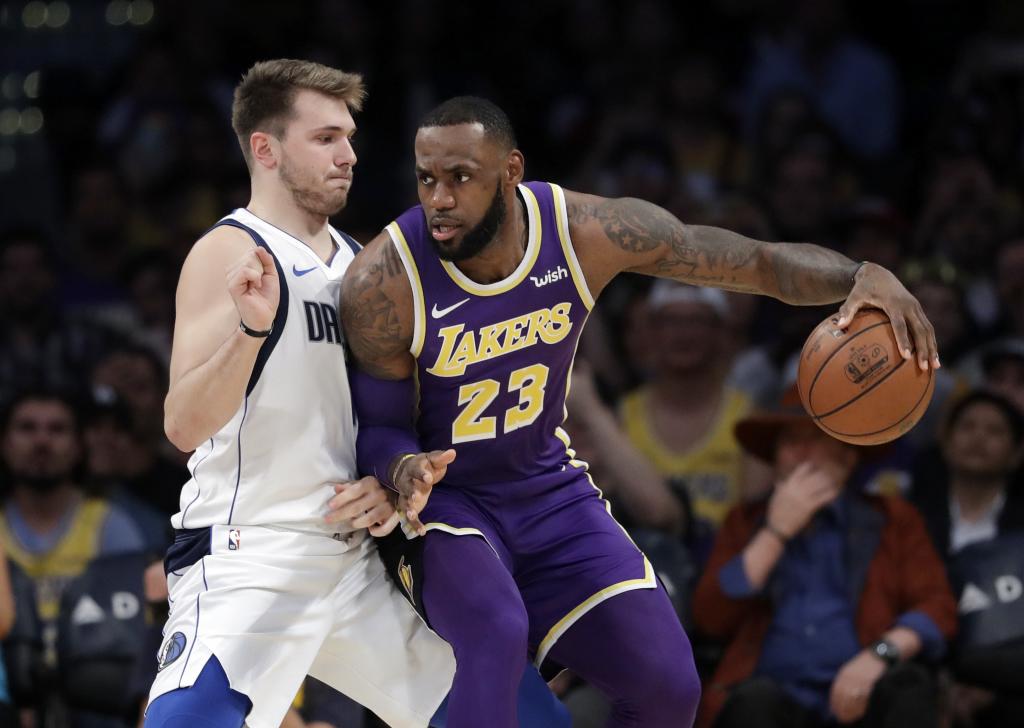 LeBron James trata de superar la defensa de Luka Doncic.