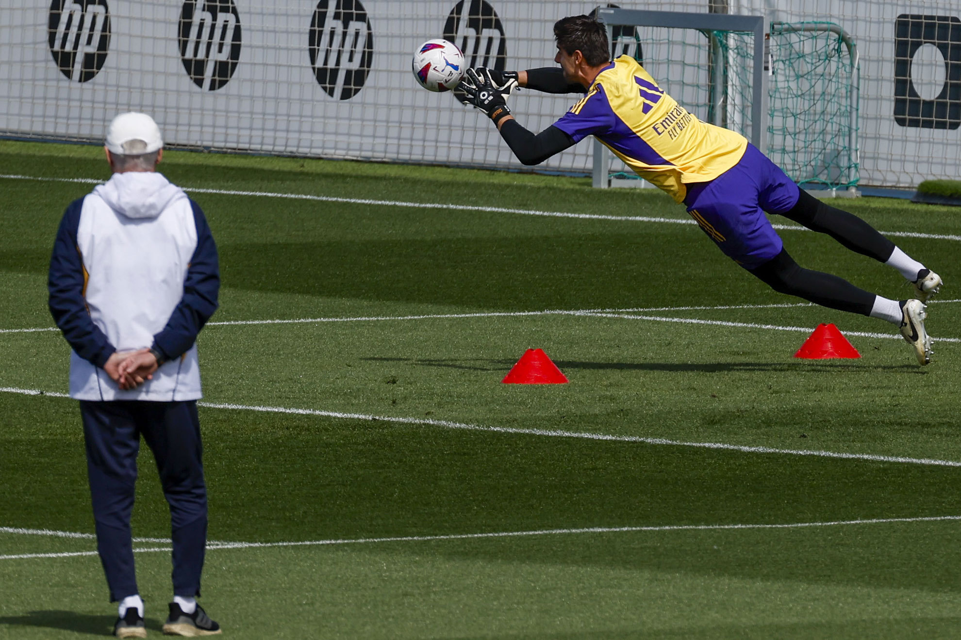 Ancelotti observa una estirada de Courtois en el entrenamiento.