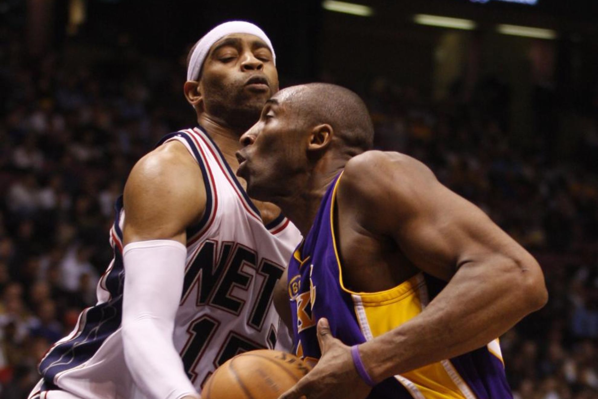 Vince Carter tries to stop Kobe Bryant in a game.