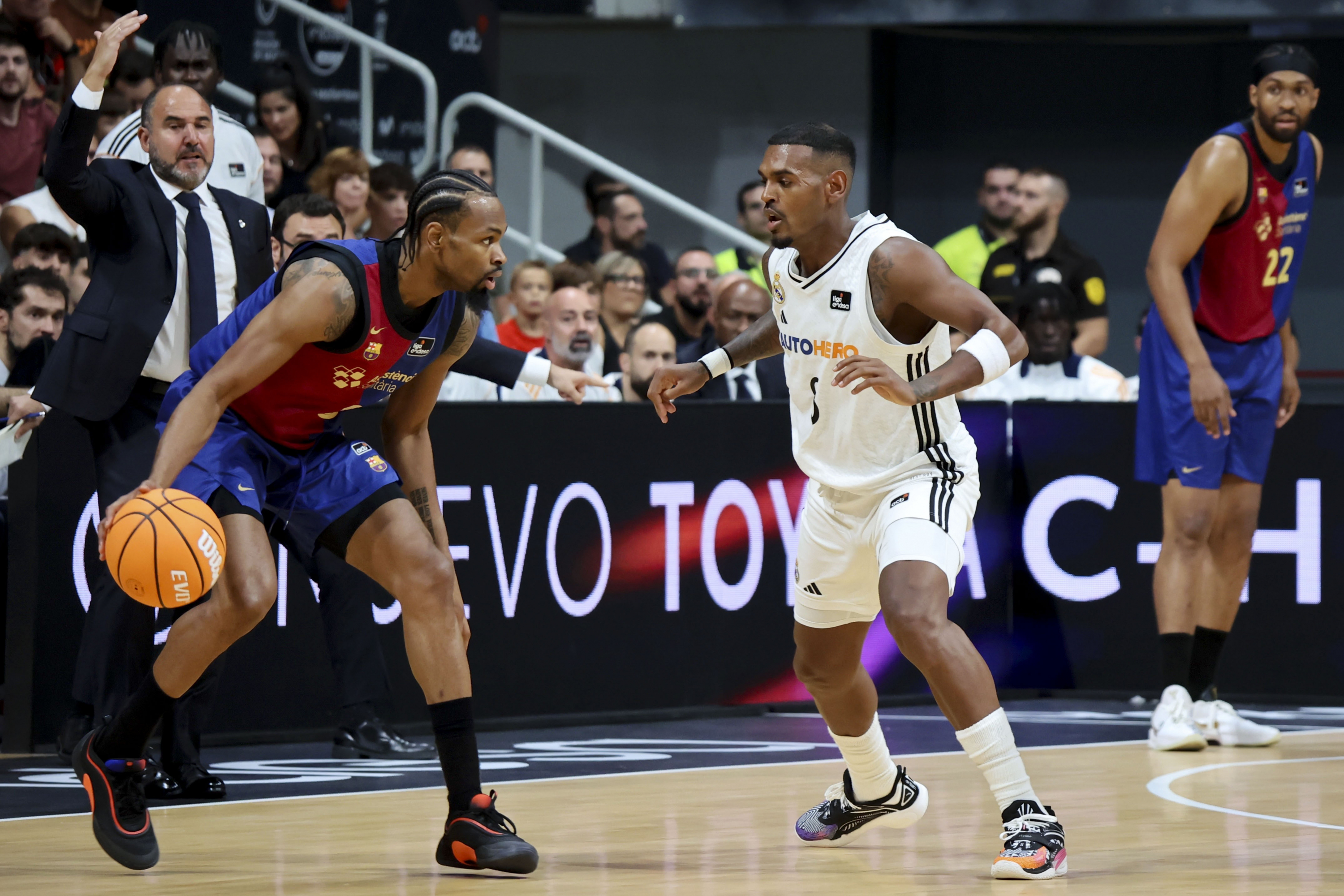 MURCIA, 21/09/2024.- El escolta estadounidense del Barça, Kevin Punter (i), con el balón ante el base canadiense del Real Madrid, Xavier Rathan-Mayes, durante la primera semifinal de la Supercopa de baloncesto que disputan hoy sábado en el Palacio de los Deportes de Murcia. EFE/Juan Carlos Caval.