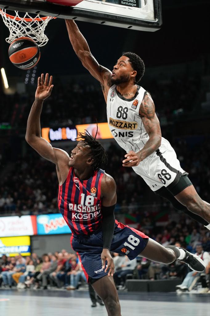 Center Partizan Amerika Tyrique Jones melakukan dunk melawan Khalifa Diop