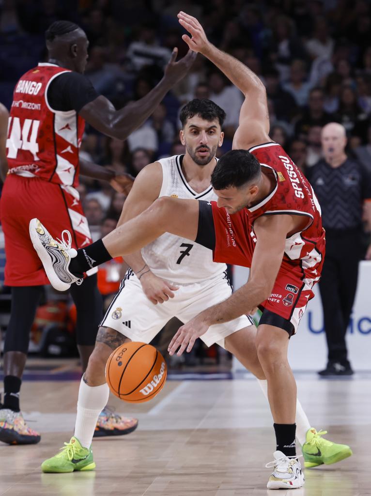 Playmaker Real Madrid asal Argentina Facundo Campazzo (belakang) membela playmaker Italia Marco Spissu dari Casademont Zaragoza.