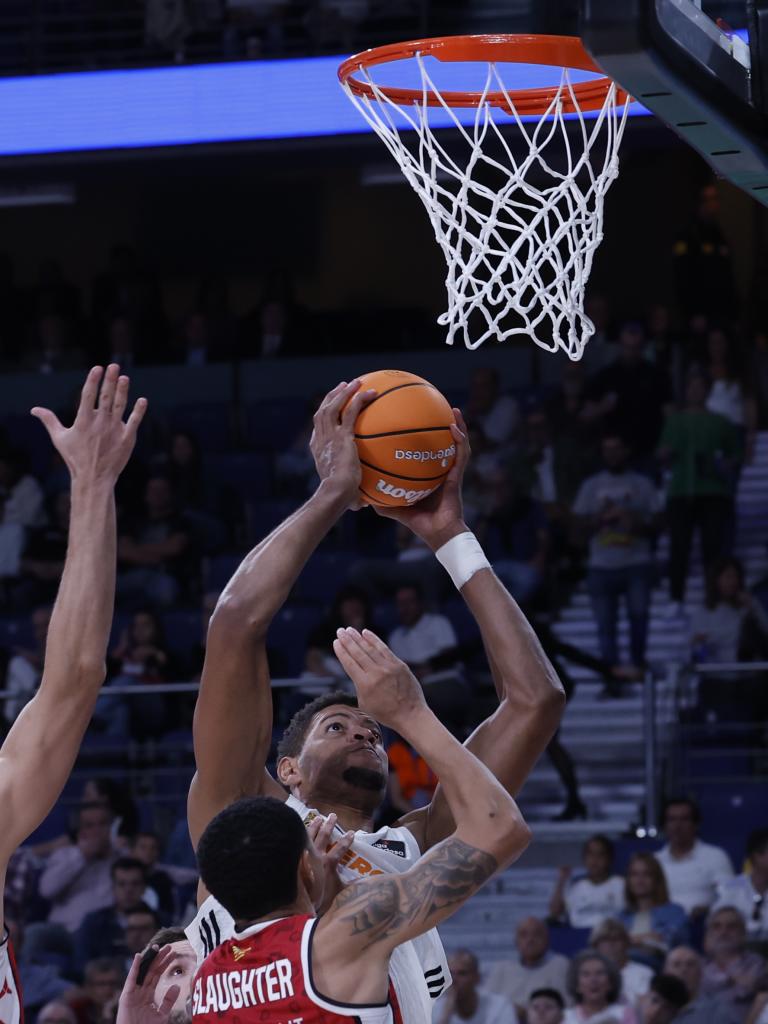 Center Real Madrid Tanjung Verde Edy Tavares (belakang) melakukan lemparan ke arah AJ Slaughter dari Casademont Zaragoza.