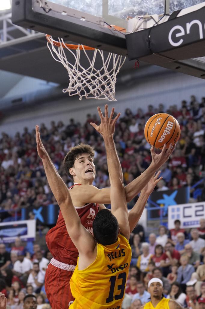 Mario Saint Supery enters a basket against Pierre Pelos