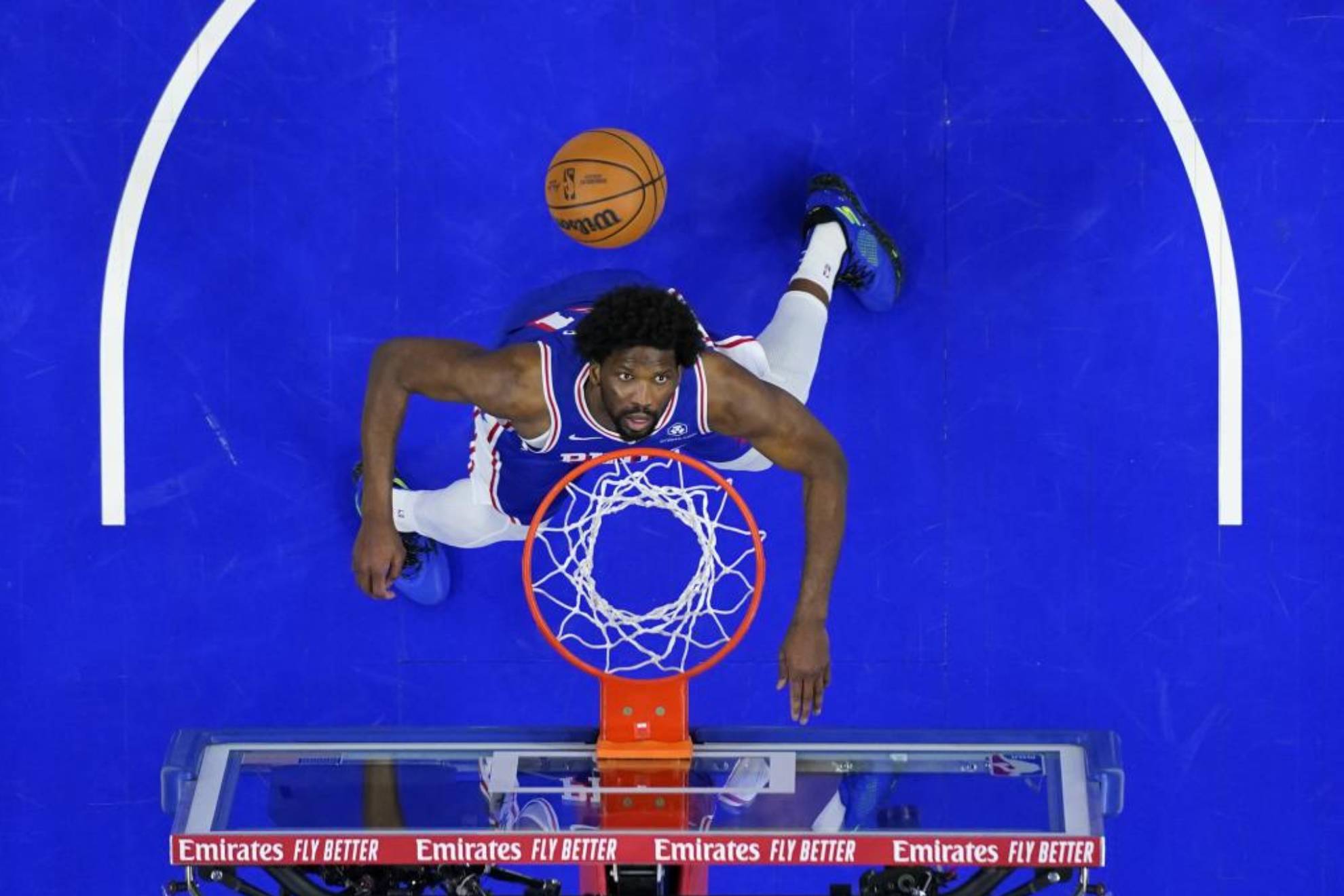 Joel Embiid se prepara para un rebote en un partido de los Sixers.