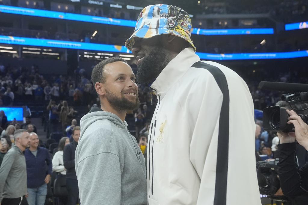 Curry e LeBron se cumprimentam após o jogo entre Warriors e Lakers que nenhum dos dois disputou.