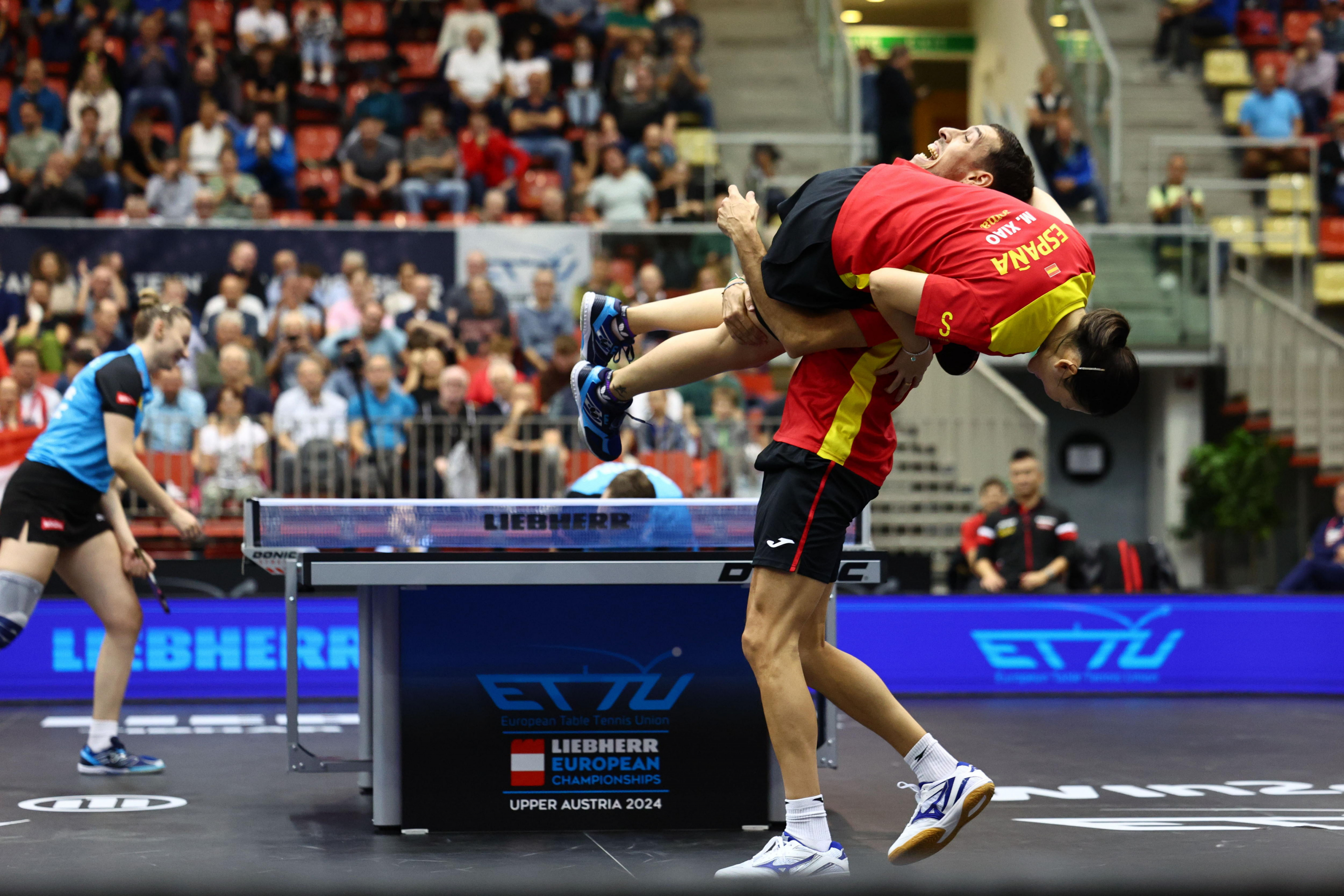 Álvaro Robles menggendong María Xiao setelah memenangkan pertandingan semifinal Kejuaraan Eropa di Linz.