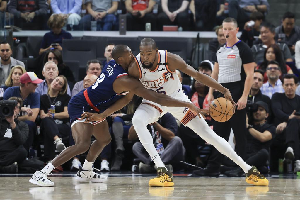 Guard LA Clippers Kris Dunn (kiri) dan forward Phoenix Suns Kevin Durant pada paruh pertama pertandingan bola basket NBA, Rabu, 23 Oktober 2024, di Inglewood, California (AP Photo/Ryan Sun)