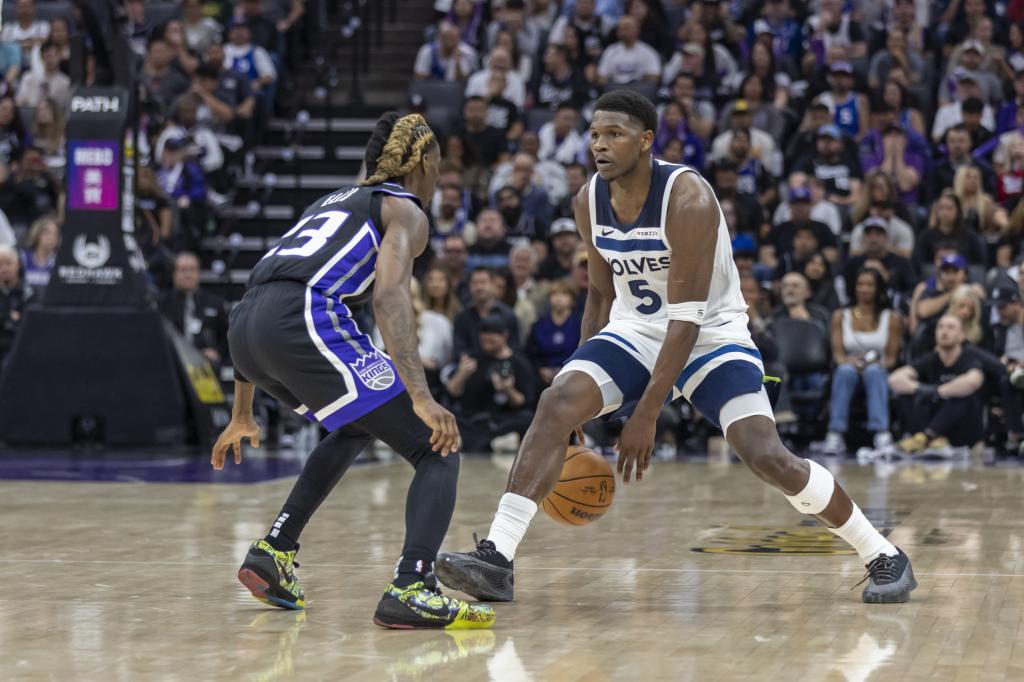 Obrońca Minnesota Timberwolves Anthony Edwards (5) kozłuje piłkę z obrońcą Sacramento Kings Keonem Ellisem (23) w obronie podczas drugiej połowy meczu koszykówki NBA. Czwartek, 24 października 2024 r. w Sacramento w Kalifornii. Timberwolves wygrali 117-115 . (AP Photo/Sara Nevis)