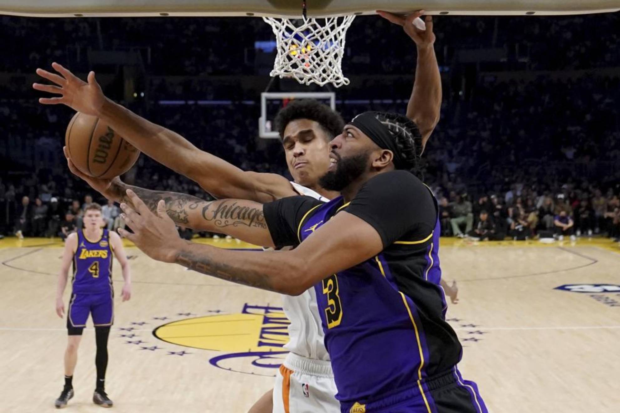 Anthony Davis trata de anotar ante la defensa de Oso Ighodaro.