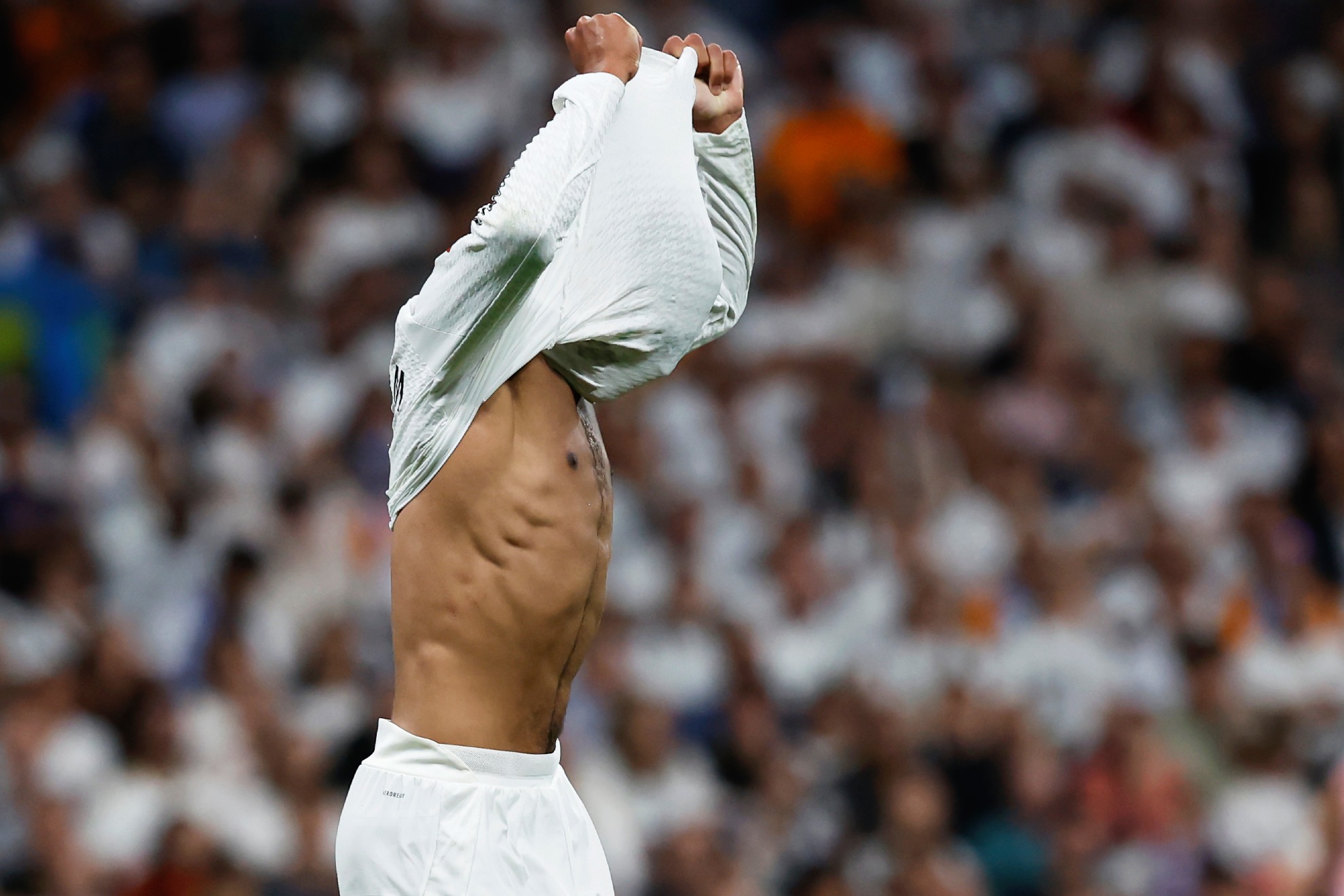 Un jugador del Real Madrid se tapa la cabeza con la camiseta.