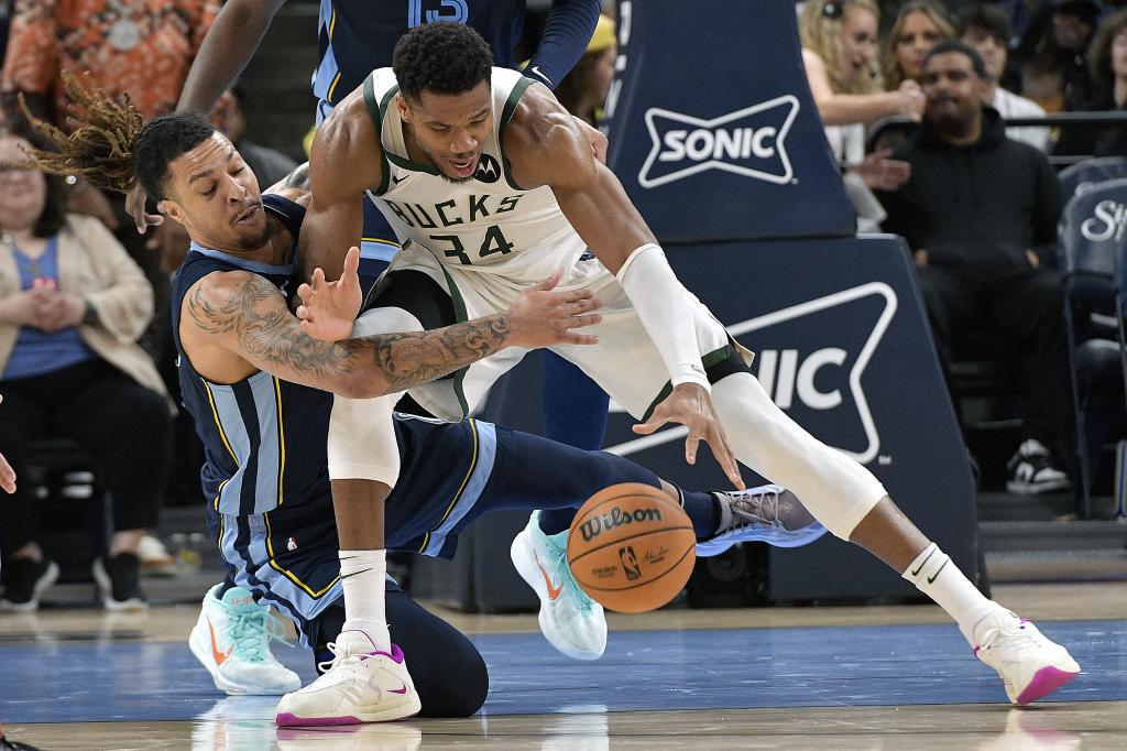 Giannis Antetokounmpo pelea por un balón con Brandon Clarke.