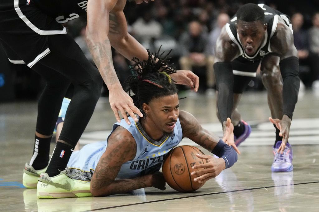 Ja Morant dari Memphis Grizzlies (bawah) melihat setelah pelanggaran dari sisi kanan yang dilakukan Dennis Schroder dari Brooklyn Nets pada paruh kedua pertandingan bola basket NBA, Senin, 4 November 2024, di New York. Nets mengalahkan Grizzlies 106-104. (Foto AP/Seth Wenig)