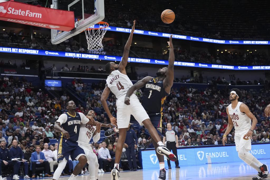 Napastnik New Orleans Pelicans Zion Williamson (1) strzela do napastnika Cleveland Cavaliers Evana Mobleya (4) w drugiej połowie meczu koszykówki NBA w Nowym Orleanie, środa, 6 listopada 2024 r. Cavaliers wygrali 131-122. (AP Photo/Gerald Herbert)