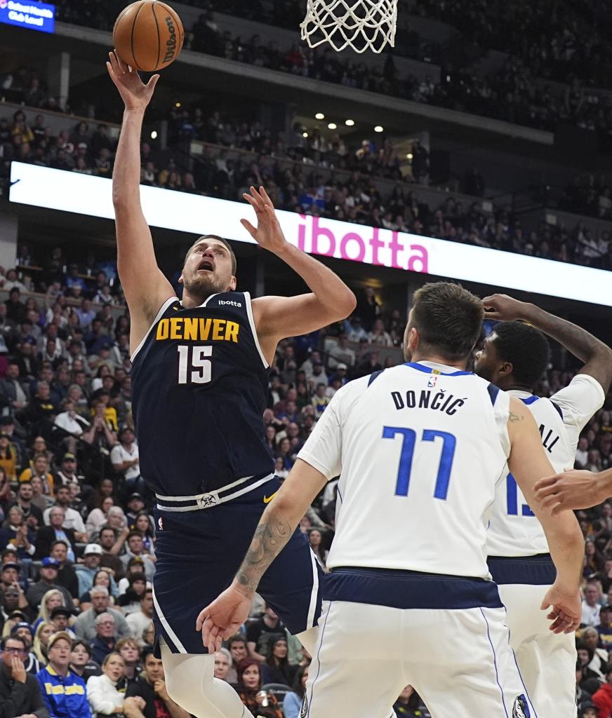 Nikola Jokic throws in the presence of Luka Doncic.