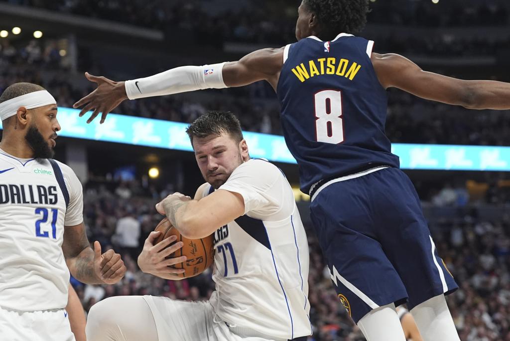 Luka Doncic protects the ball from Peyton Watson's defense.