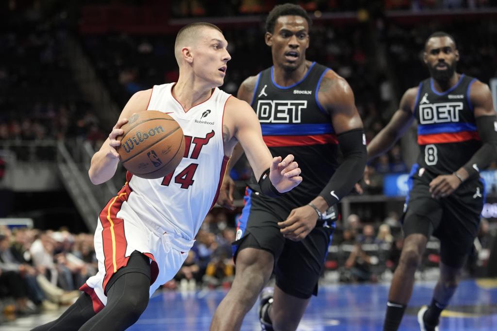 Tyler Herro intenta superar a Jalen Duren durante el partido Pistons-Heat.