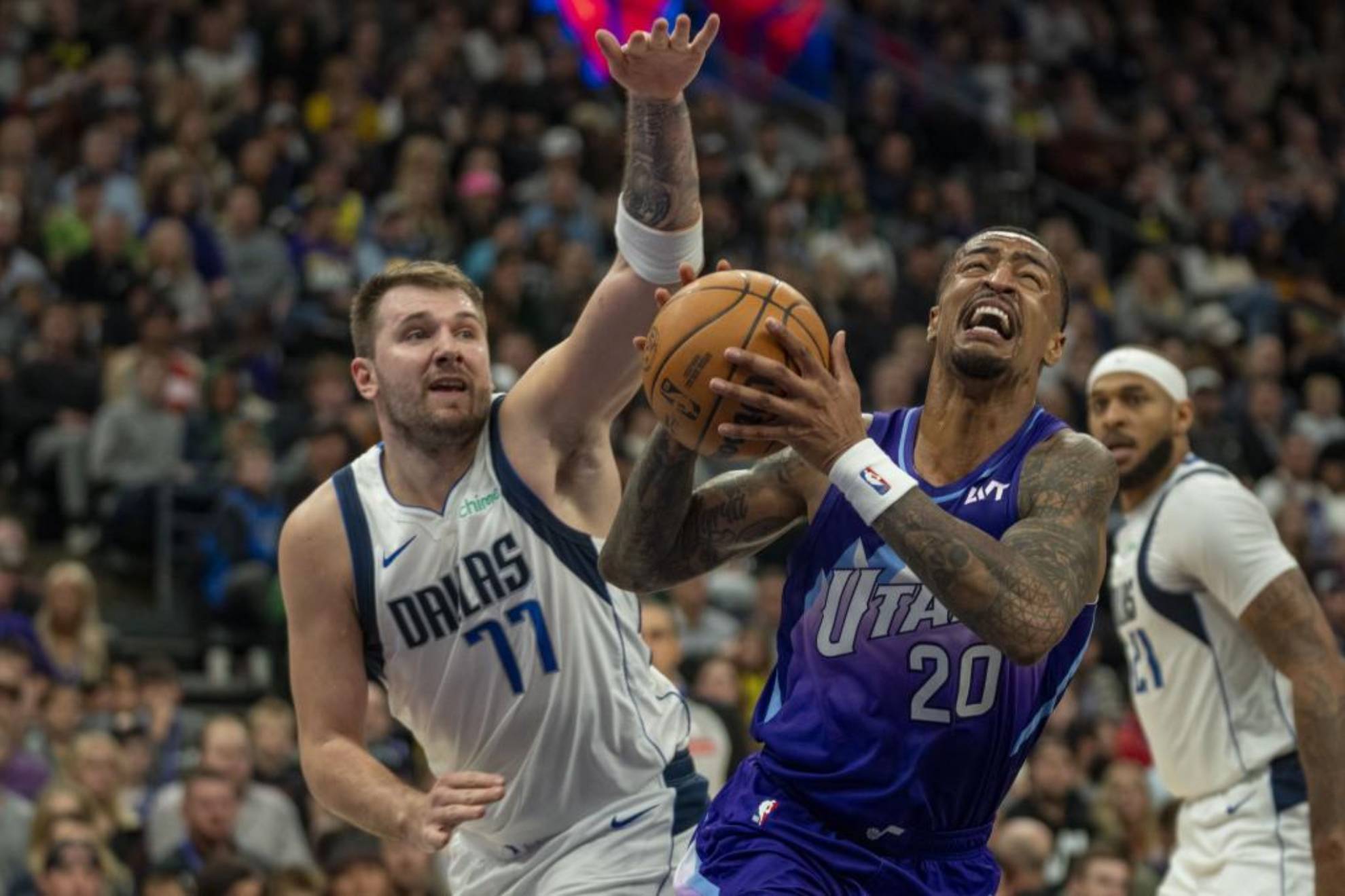 John Collins supera la defensa de Luka Doncic.