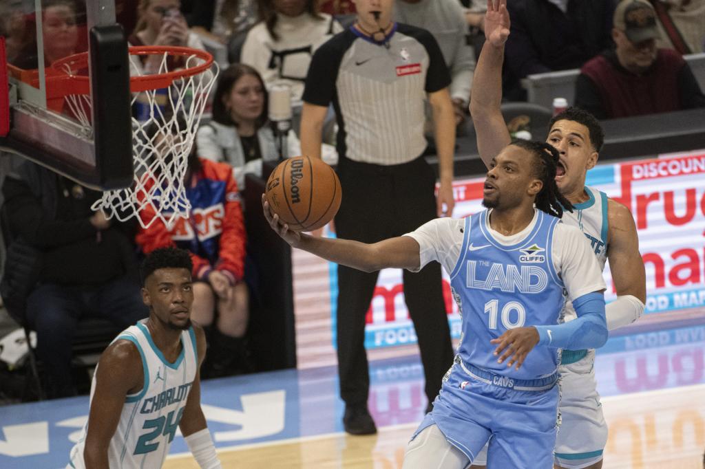 Darius Garland (10 l.) z Cleveland Cavaliers przygotowuje ustawienie, podczas gdy Josh Green (z prawej) i Brandon Miller (24 l.) z Charlotte Hornets przyglądają się pierwszej połowie meczu koszykówki NBA w Cleveland, w niedzielę 17 listopada 2024 r. (AP Photo/Phil Long)