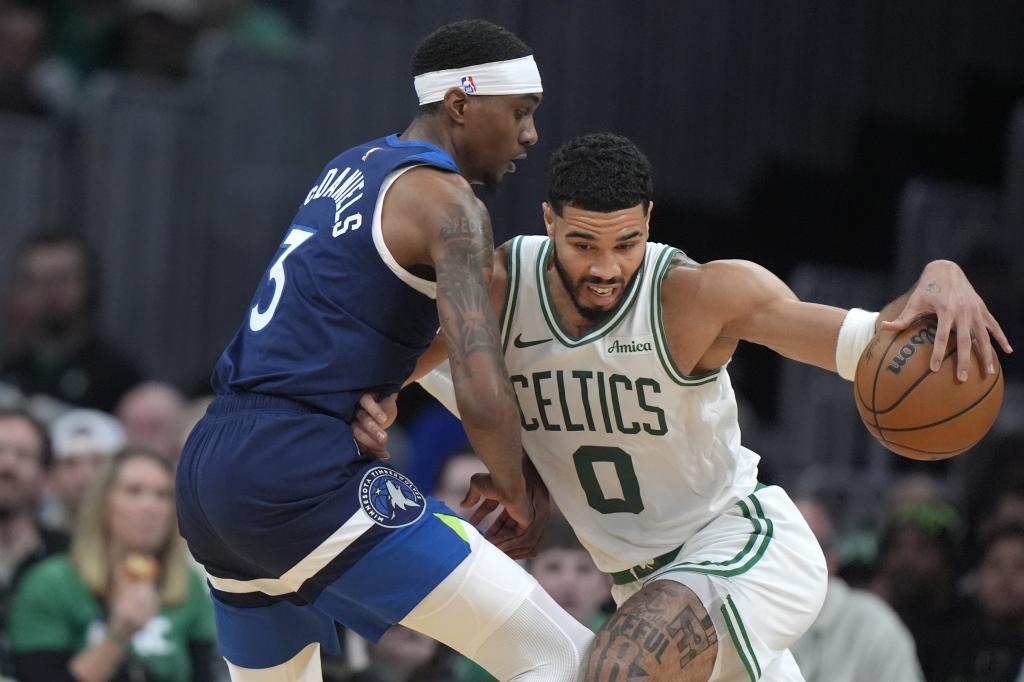 Jayson Tatum trata de eludir a Jaden McDaniels.