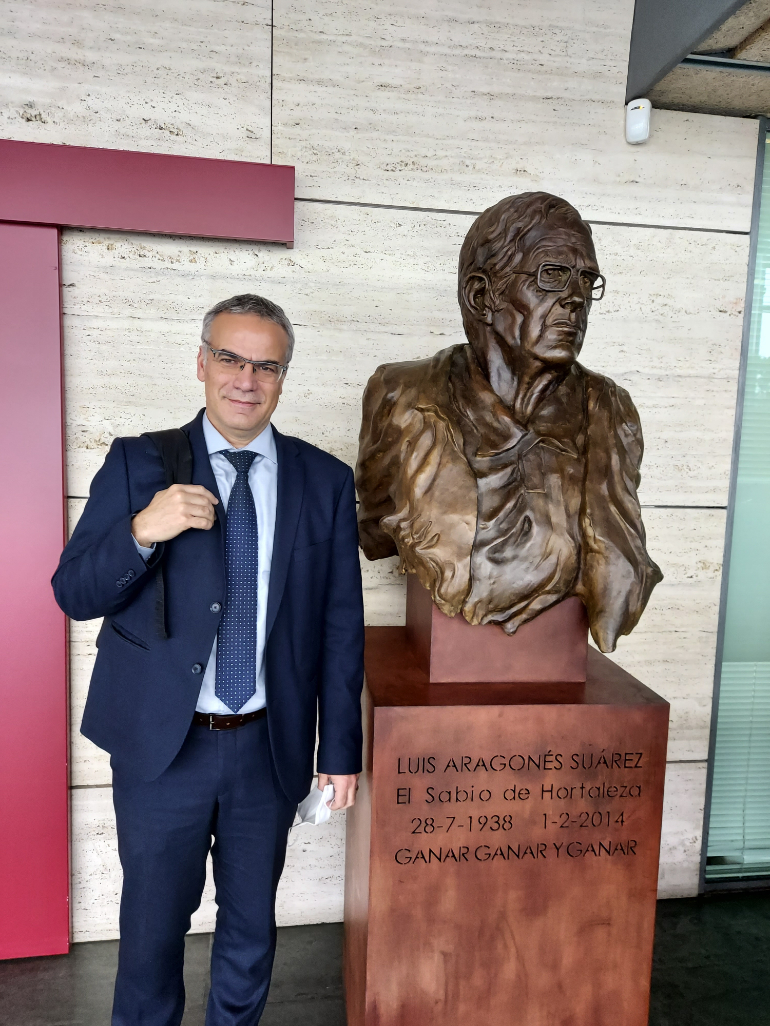 Manu Díaz posa en las instalaciones de la Federación Española junto a la estatua a Luis Aragonés