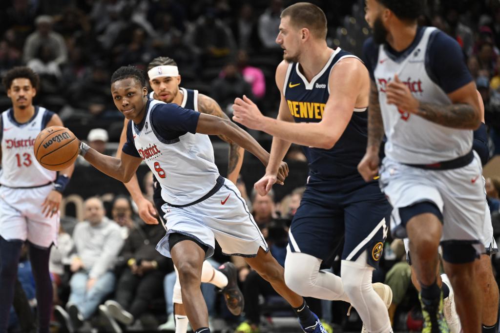 Washington Wizards guard Carlton Carrington (8) races up the floor against Denver Nuggets center Nikola Jokic, second from right, during the first half of an NBA basketball game Saturday, Dec. 7, 2024, in Washington. (AP Photo/John McDonnell)