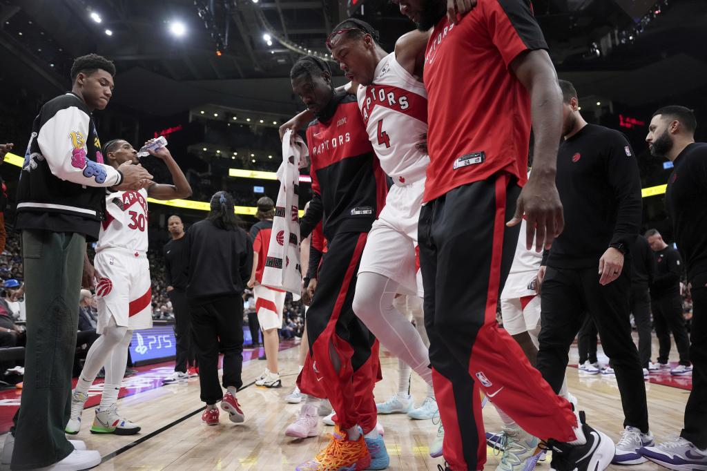 Toronto Raptors forward Scottie Barnes (4) is helped off the court after suffering an injury during the second half of an NBA basketball game against the New York Knicks, in Toronto, Monday, Dec. 9, 2024. (Nathan Denette/The Canadian Press via AP)