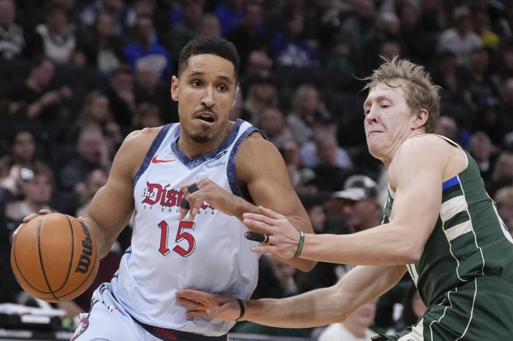 Malcolm Brogdon intenta superar a AJ Green en un Wizards-Bucks.