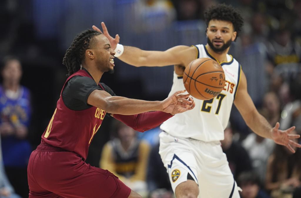Darius Garland da una asistencia ante la mirada de Jamal Murray.
