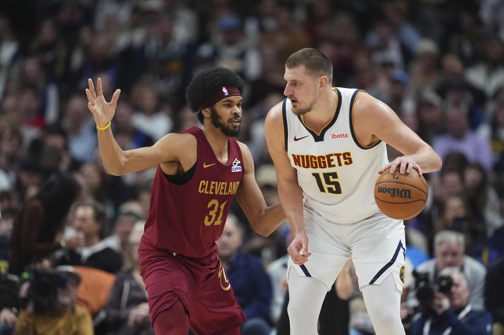 Nikola Jokic busca a quién pasar el balón presionado por Jarrett Allen.