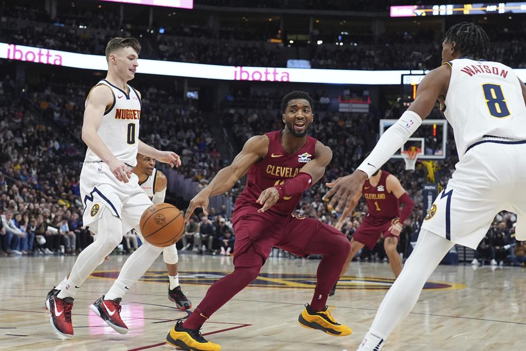 Donovan Mitchell pasa el balón ante la presión defensiva de Braun y Watson.