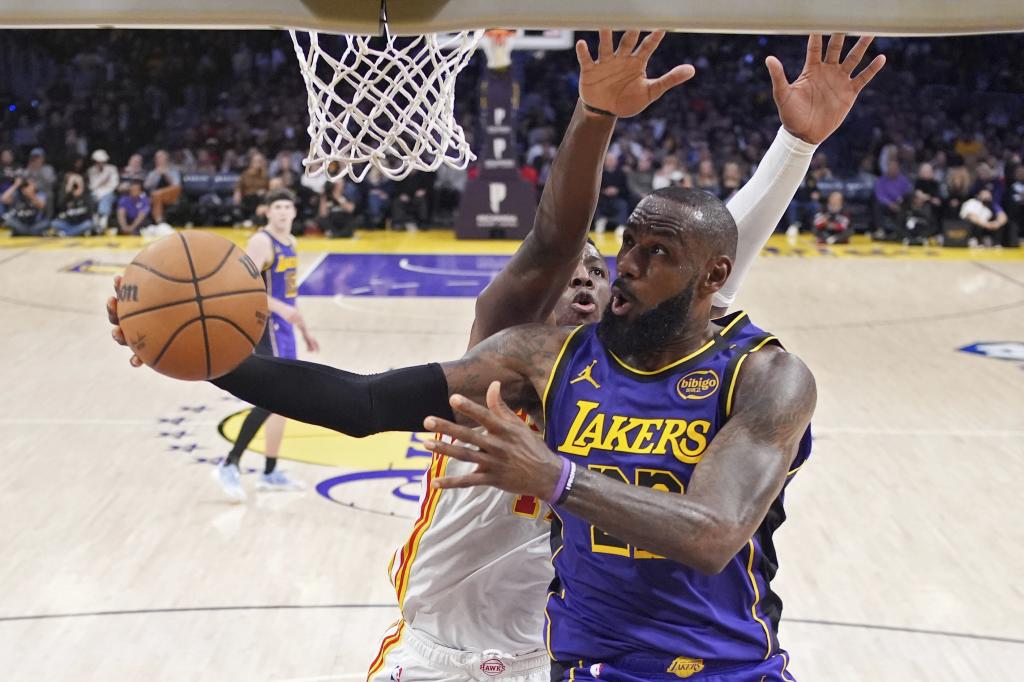 Los Angeles Lakers forward LeBron James, right, shoots as Atlanta Hawks forward Onyeka Okongwu defends during the second half of an NBA basketball game, Friday, Jan. 3, 2025, in Los Angeles. (AP Photo/Mark J. Terrill)