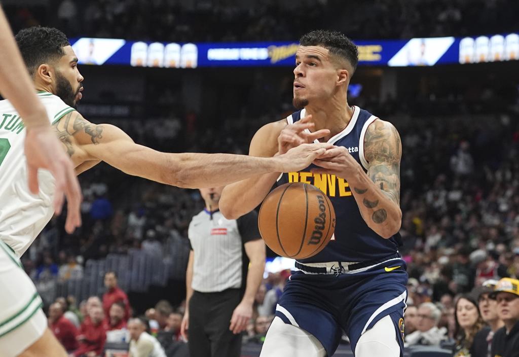 Boston Celtics forward Jayson Tatum, left, knocks the ball out of the hands of Denver Nuggets forward Michael Porter Jr. in the second half of an NBA basketball game Tuesday, Jan. 7, 2025, in Denver. (AP Photo/David Zalubowski)