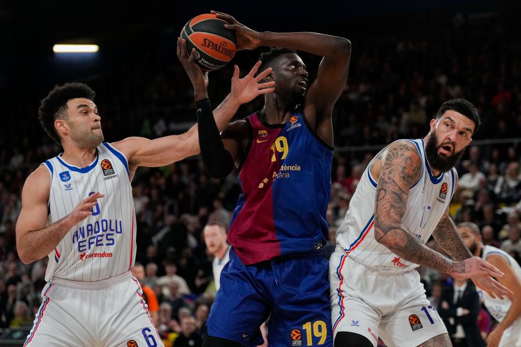 Youssoupha Fall trata de levantar el balón entre Elijah Bryant y Vincent Poirier.