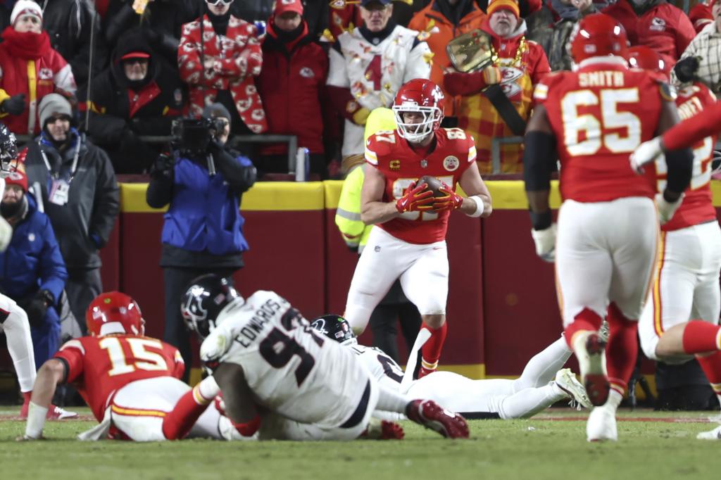 Kansas City Chiefs tight end Travis Kelce catches a touchdown pass from quarterback Patrick Mahomes (15) as Houston Texans defensive tackle Mario Edwards Jr. (97) defends during the second half of an NFL football AFC divisional playoff game Saturday, Jan. 18, 2025 , in Kansas City, Mo. (AP Photo/Travis Heying)