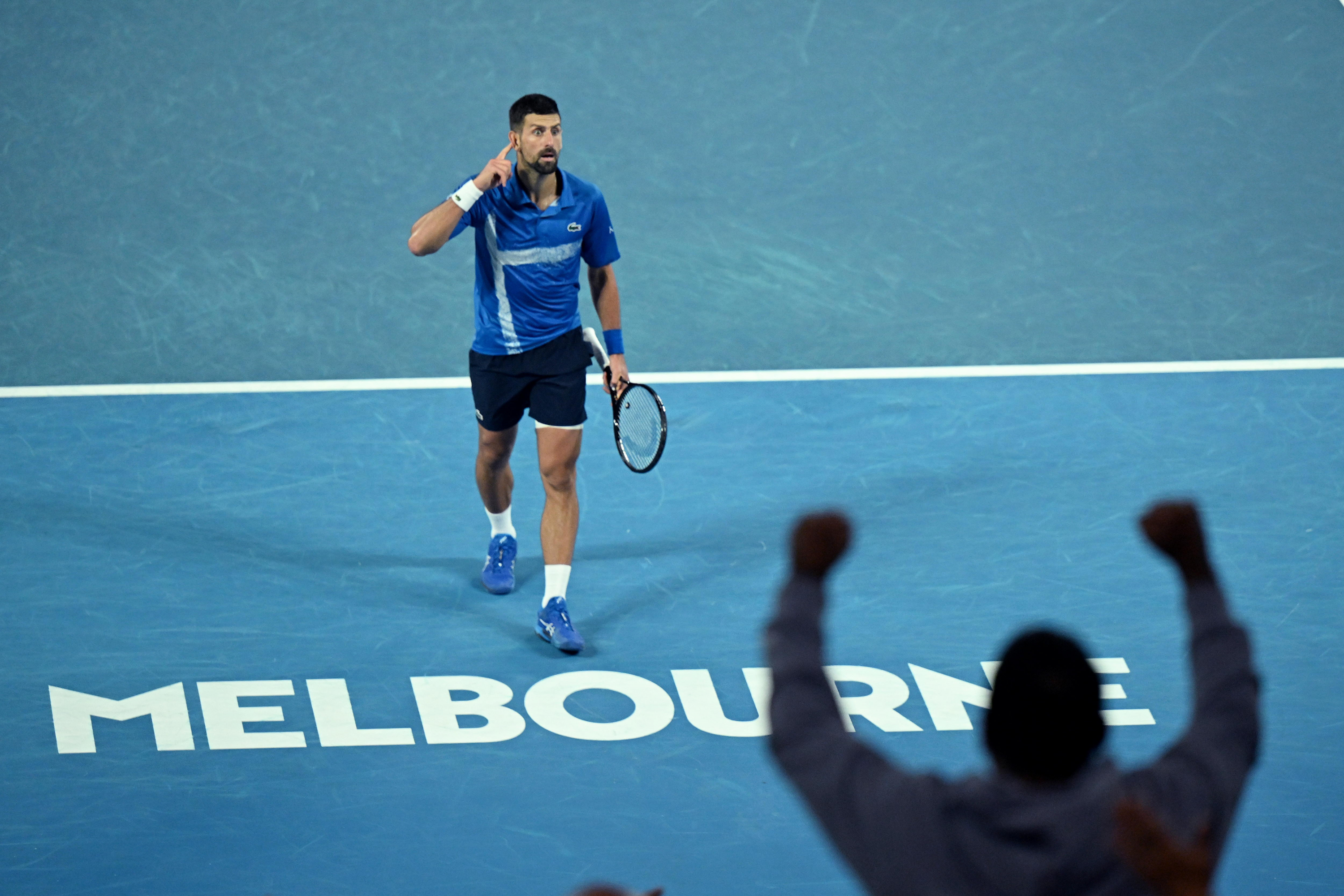 Novak se echa la mano a la oreja para escuchar a los aficonados.