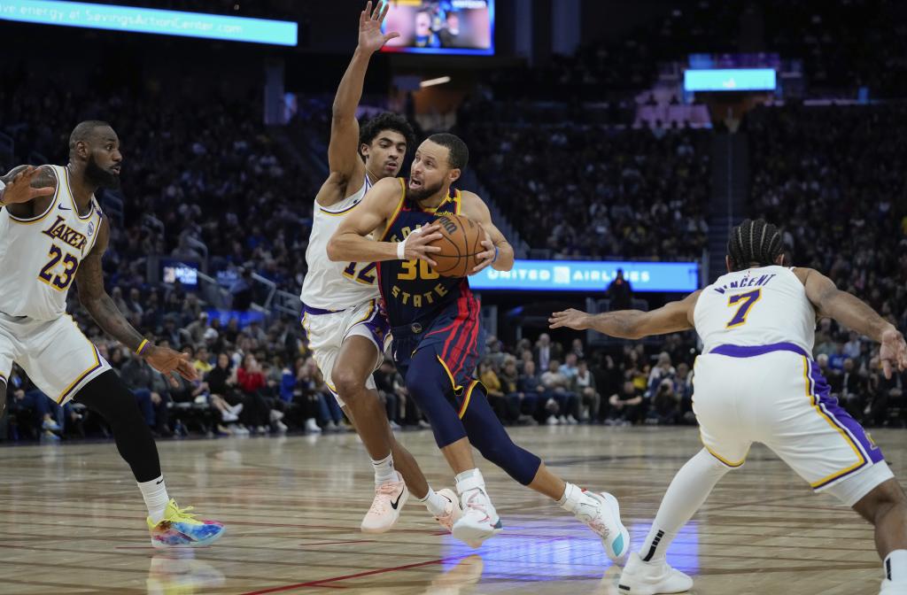 Stephen Curry entra a canasta defendido por Max Christie.