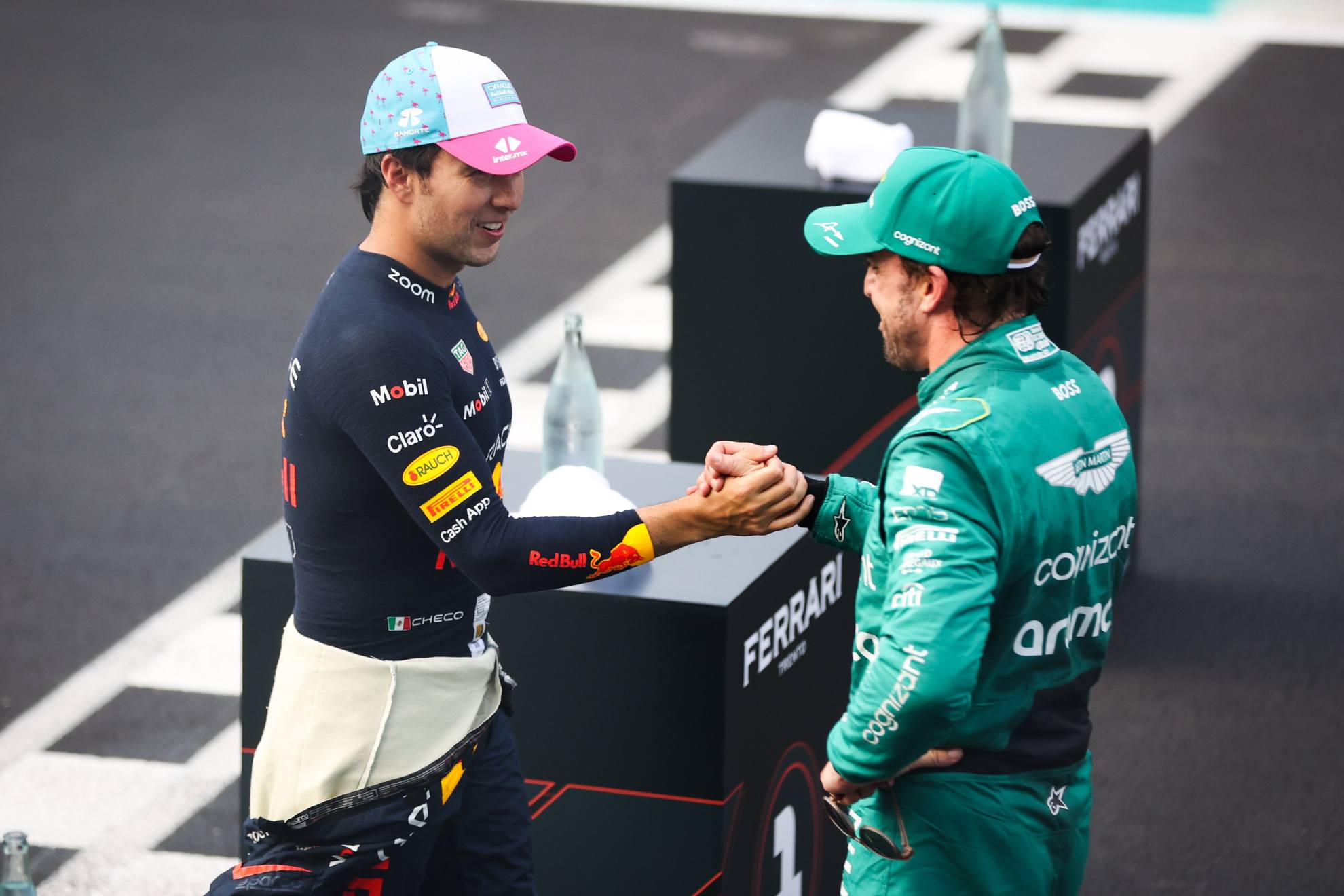 Checo Pérez y Fernando Alonso se saludan en un podio de 2023.